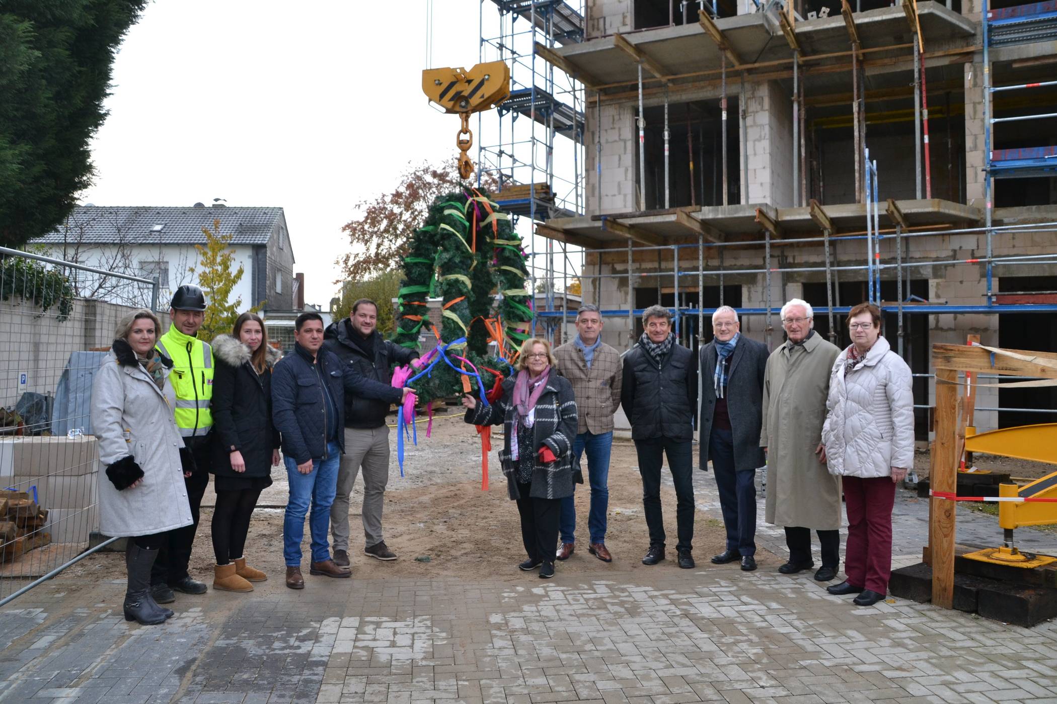 Vertreter der Malteser Rhein Ruhr, der Projektentwickler, des Baugewerbes und der Politik waren zugegen, als die geschmückte Richtkrone vom Baukran in die Höhe gezogen wurde.