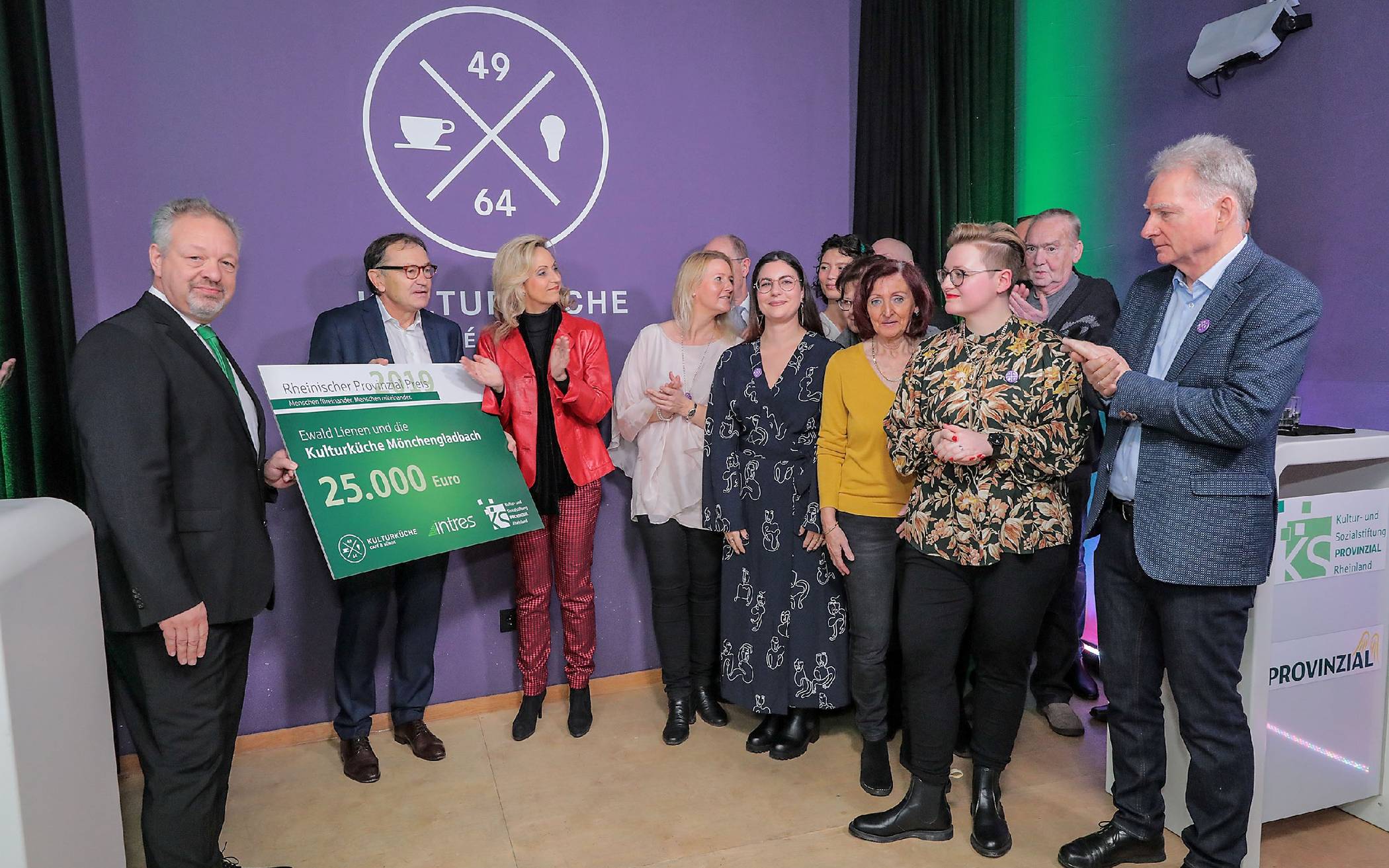 „Pate“ Ewald Lienen (2.v.l.), Patric Fedlmeier, Vorstandsvorsitzender der Provinzial Rheinland (l.) und Ulrike Lubek (3.v.l.), Direktorin des Landschaftsverbandes Rheinland, überreichen den mit 25<nbsp code="8201"/>000 Euro dotierten Scheck an das Team der Kulturküche mit Hannah und Norbert von Dahlen (vorne r.).