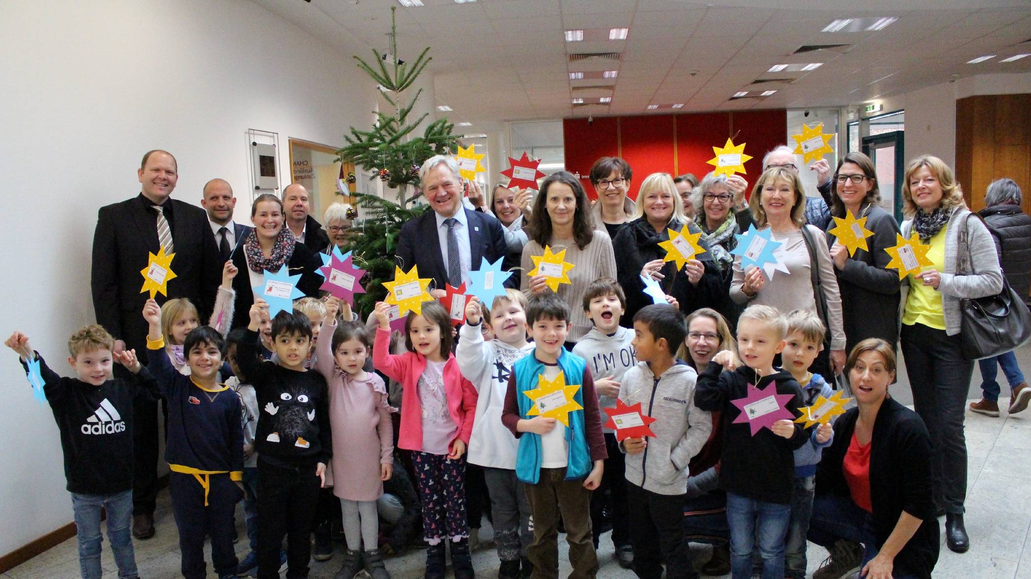  In der Sparkasse in Alt-Willich haben Kinder und der Bürgermeister die ersten Wunschsterne an den Weihnachtsbaum gehangen. 