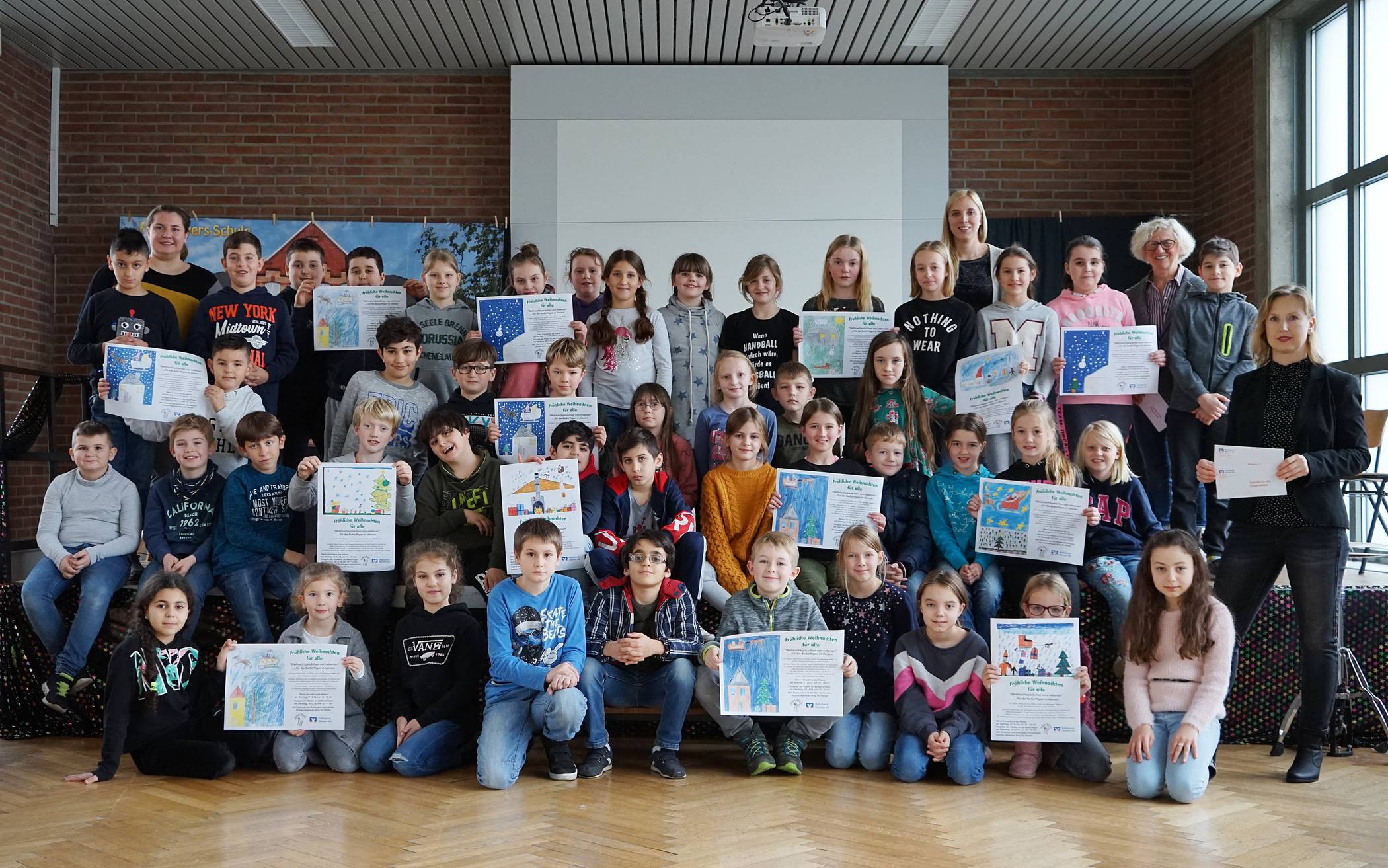 Die Kinder der Paul-Weyers-Schule mit Lehrerinnen sowie Luzia Witthake (o.r.) von der Tafel und Anke Krützberg, stellvertretende Leiterin Marktbereich Dülken, die die Spende der Volksbank Viersen übergab.