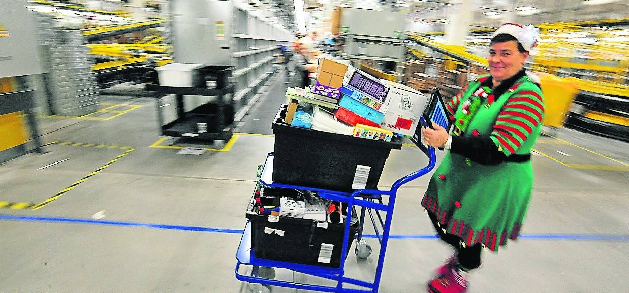  Eine Amazon-Versandmitarbeiterin im Weihnachts-Outfit: Speziell in der Vorweihnachtszeit hatte die Belegschaft alle Hände voll zu tun – beziehungsweise viele Päckchen zu packen... 