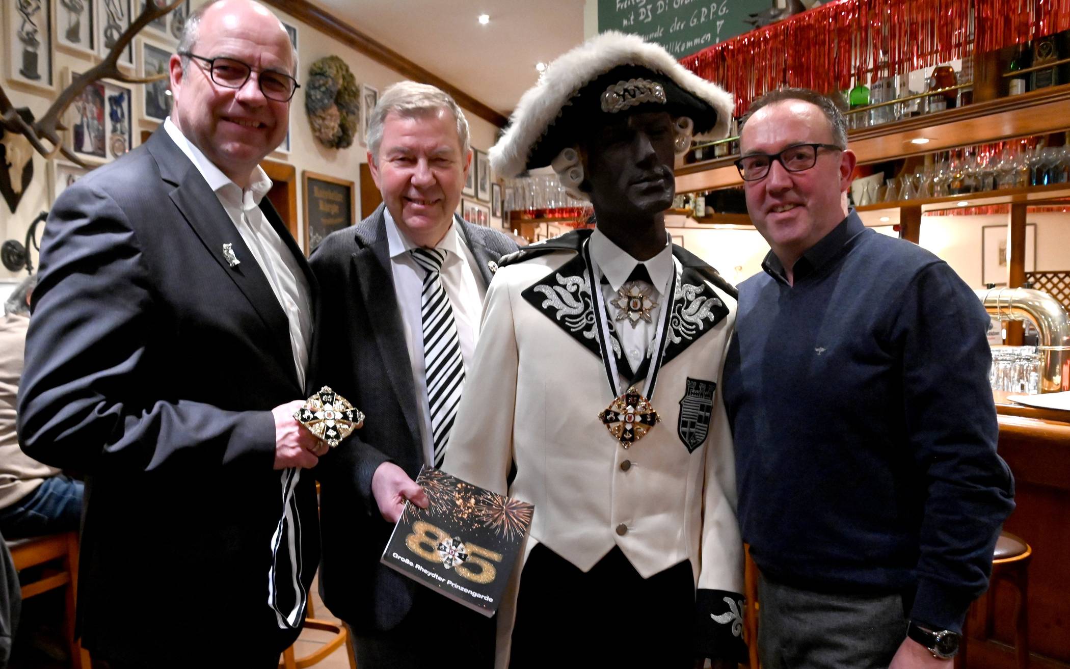 Die Große Rheydter Prinzengarde feiert ihr 85-jähriges Bestehen. Stolz präsentieren Schatzmeister Christoph Ringel, Präsident Dieter Beines und der Vorsitzende Holger Vits (v.l.) Jubiläumsorden und Jubiläumsbuch.