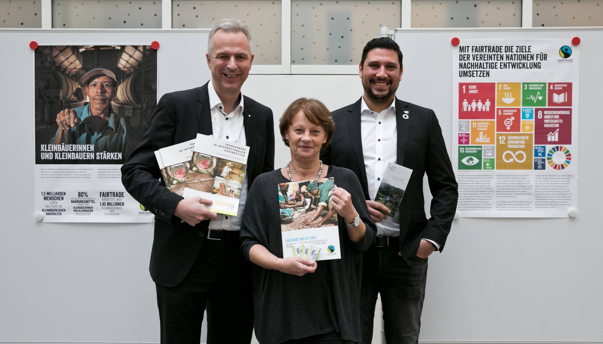   Kreisdirektor Dirk Brügge (links), Thiago de Carvalho Zakrzewski und Renate Kuglin eröffnen die Ausstellung „Nachhaltig handeln – Arbeitsschwerpunkte von Fairtrade“ im Kreishaus Neuss. 