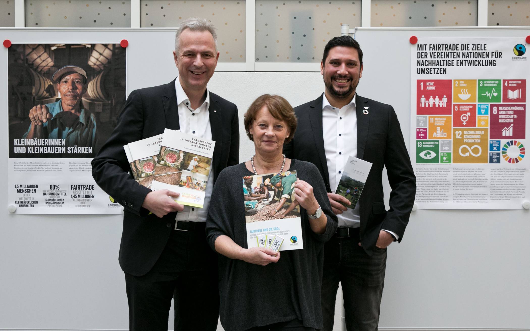  Kreisdirektor Dirk Brügge (links), Thiago de Carvalho Zakrzewski und Renate Kuglin eröffnen die Ausstellung „Nachhaltig handeln – Arbeitsschwerpunkte von Fairtrade“ im Kreishaus Neuss.