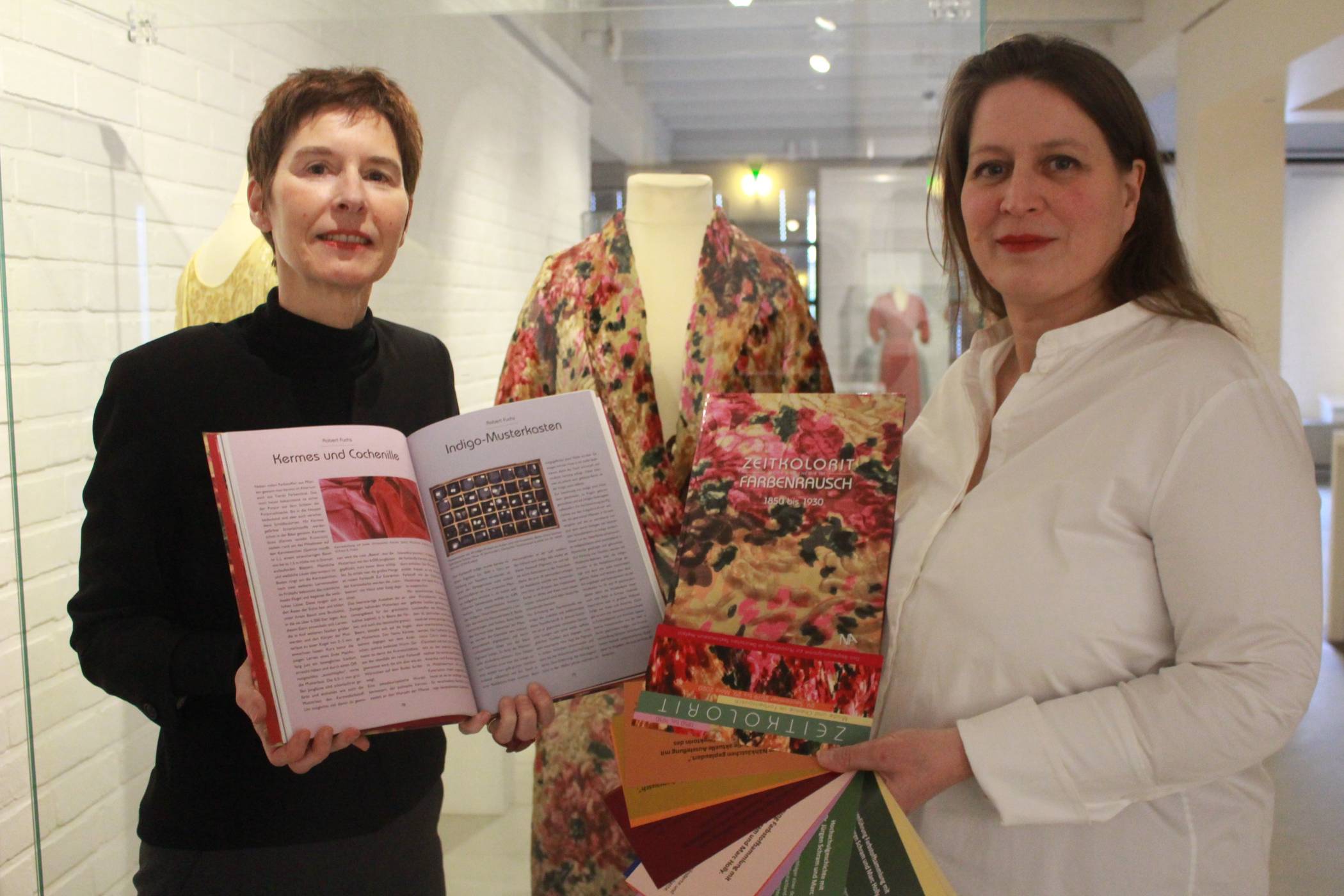 Rausch von Farben: Museumsdirektorin Dr. Annette Schieck (r.) und ihre Stellvertreterin Dr. Isa Fleischmann-Heck präsentieren den Katalog, der der Ergebnisse der Ausstellung anschaulich darstellt. Das bunte Cover entspricht einem ausgestellten, geblümten Kleid.
