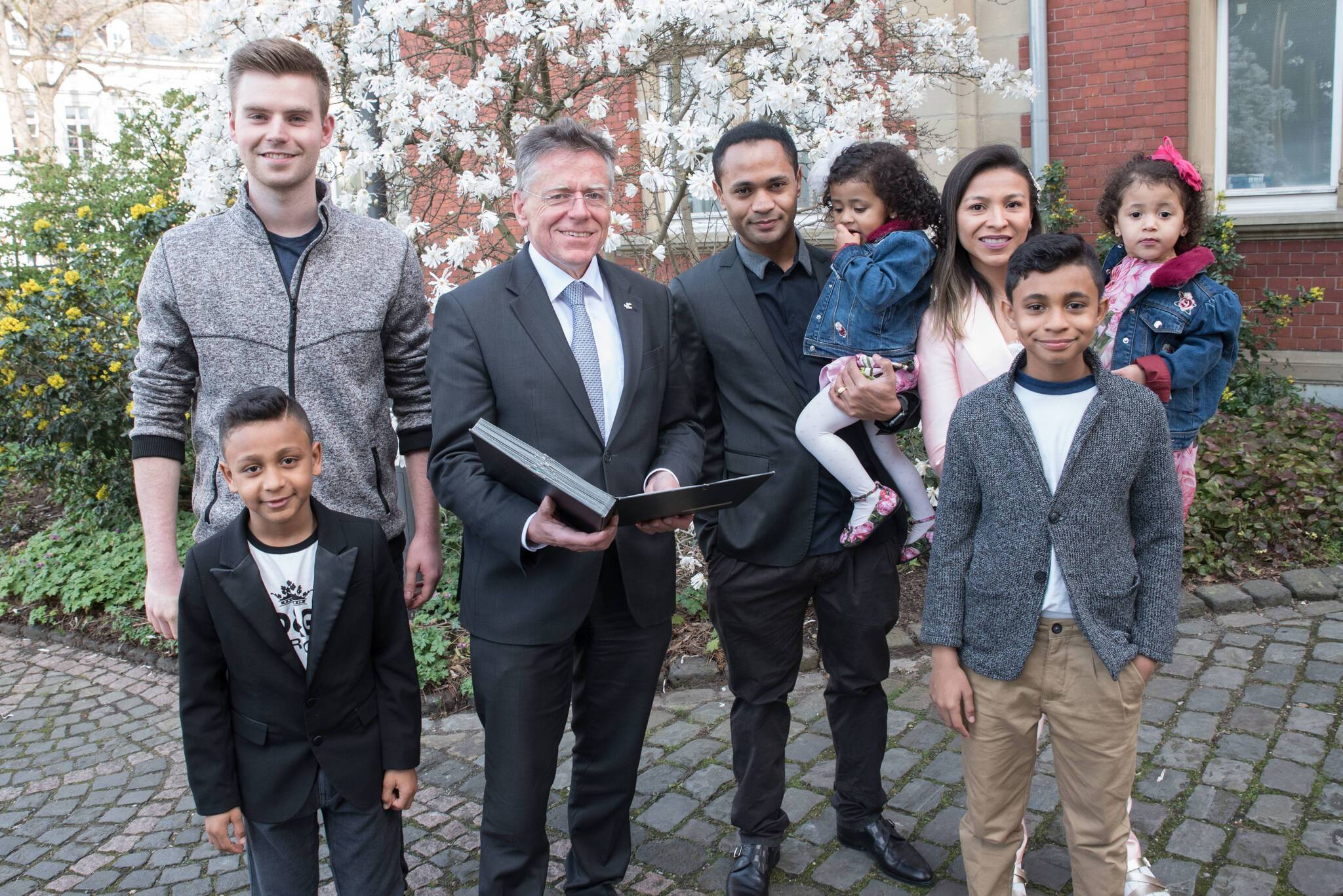  Landrat Hans-Jürgen Petrauschke überreichte die Einbürgerungsurkunde an den Borussia-Stürmer Rafael Caetano de Araújo und seine Familie im Beisein von Kreismitarbeiter Lukas Roeder (l.). 