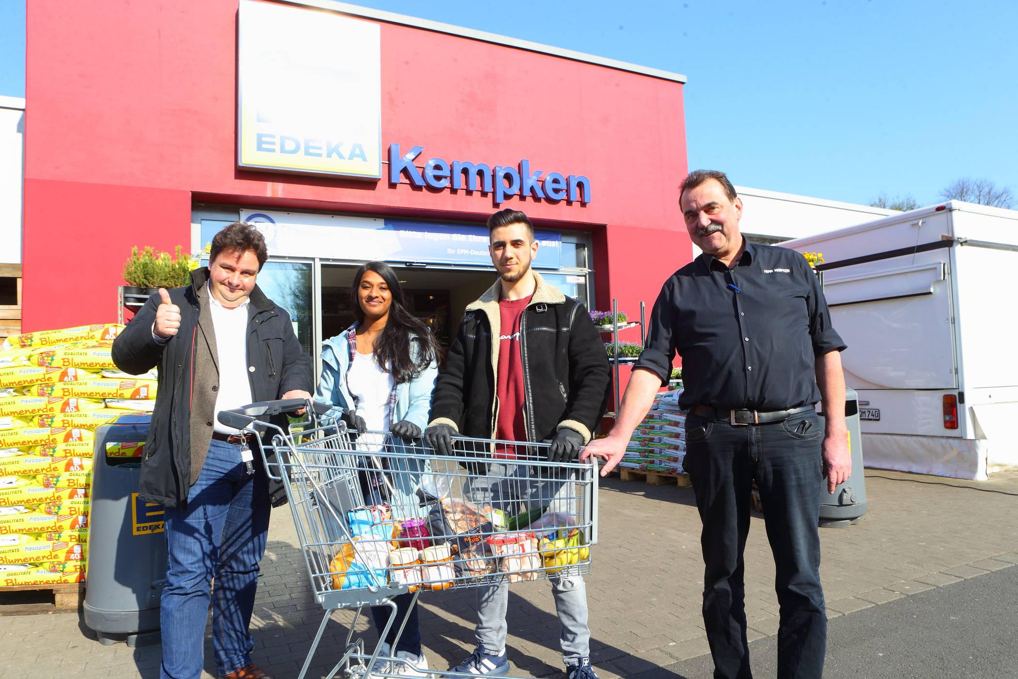 Daumen hoch und ein Dank für das große bürgerschaftliche Engagement: Krefelds Beigordneter Markus Schön (links) traf die beiden „Einkaufshelfer“ Abira Chandran und Burak Ugurlugülbüken im Supermarkt von Heiner Kempken (rechts).