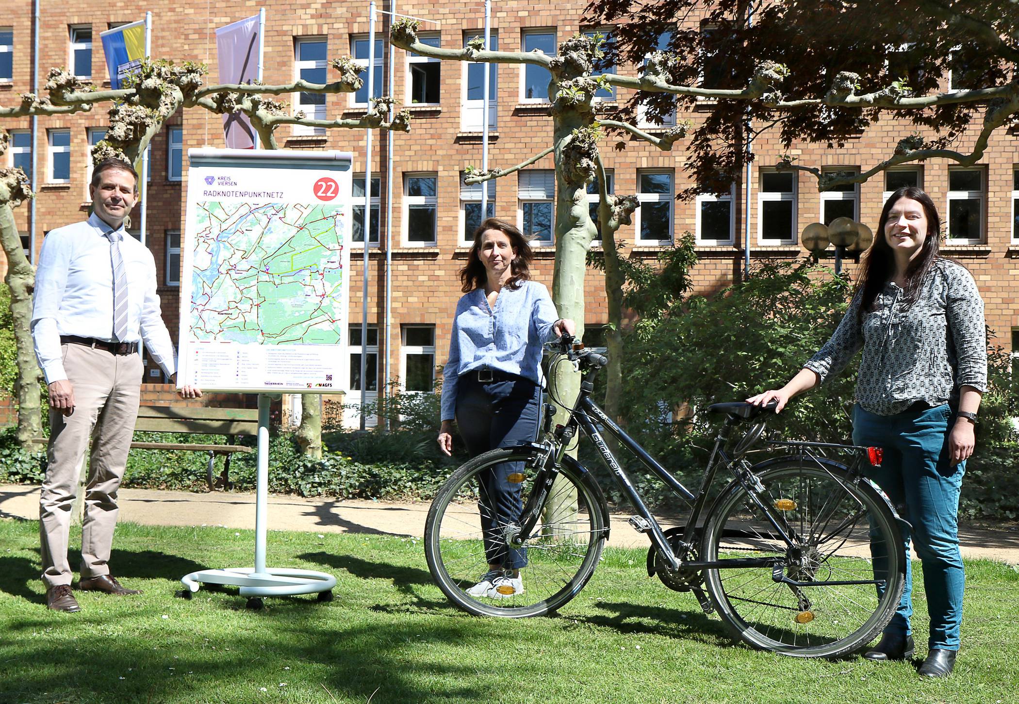  Andreas Budde, Dezernent für Planen, Bauen und Umwelt stellt mit seinen Mitarbeiterinnen Anke Faßbender und Sandra Sieg (v.l.n.r.) die neue Infotafel für das Radknotenpunktnetz vor. 