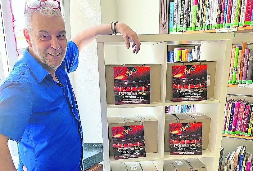  Ulrich Schmitter vor einem Teil der 5000 bereits gedruckten Programmhefte, die nun nicht mehr zu gebrauchen sind. 