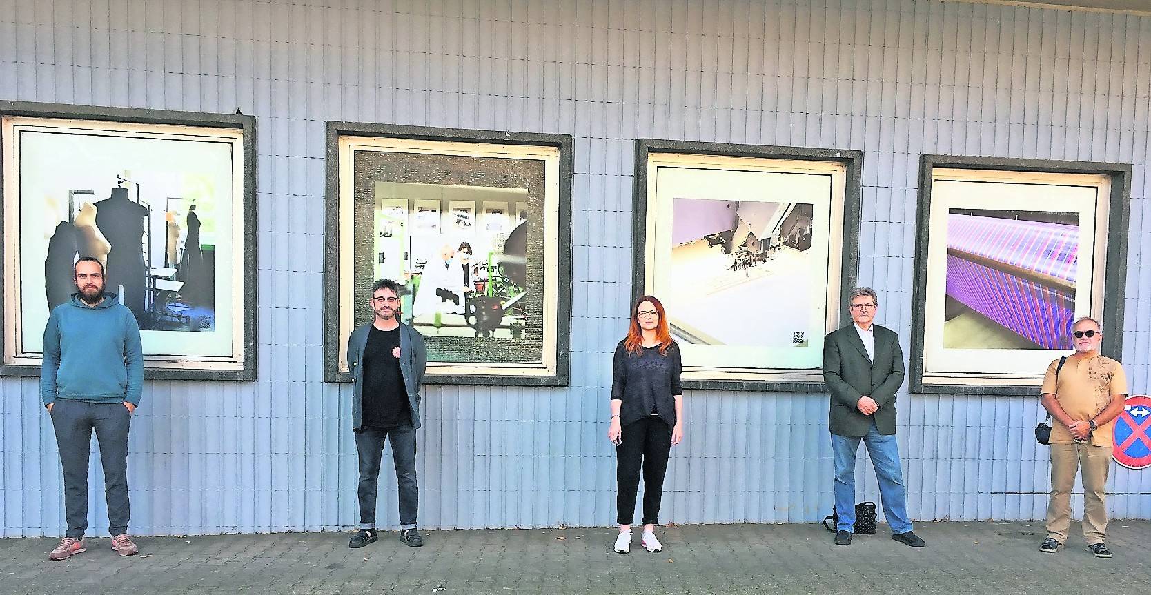 Fotokunst, die als „Roter Faden“ – wie hier am ehemaligen Schwimmbad am Berliner Platz – das Quartier Abteiberg durchzieht, präsentieren (v.l.): Fotokünstler Joshua Eckstein, Projektkoordinator Dr. Bernhard Jansen, Fotokünstlerin Cora Straßburg, Karl Sasserath (Leiter des Arbeitslosenzentrums) und Dietmar Jung (Vorstand des Arbeitslosenzentrums).