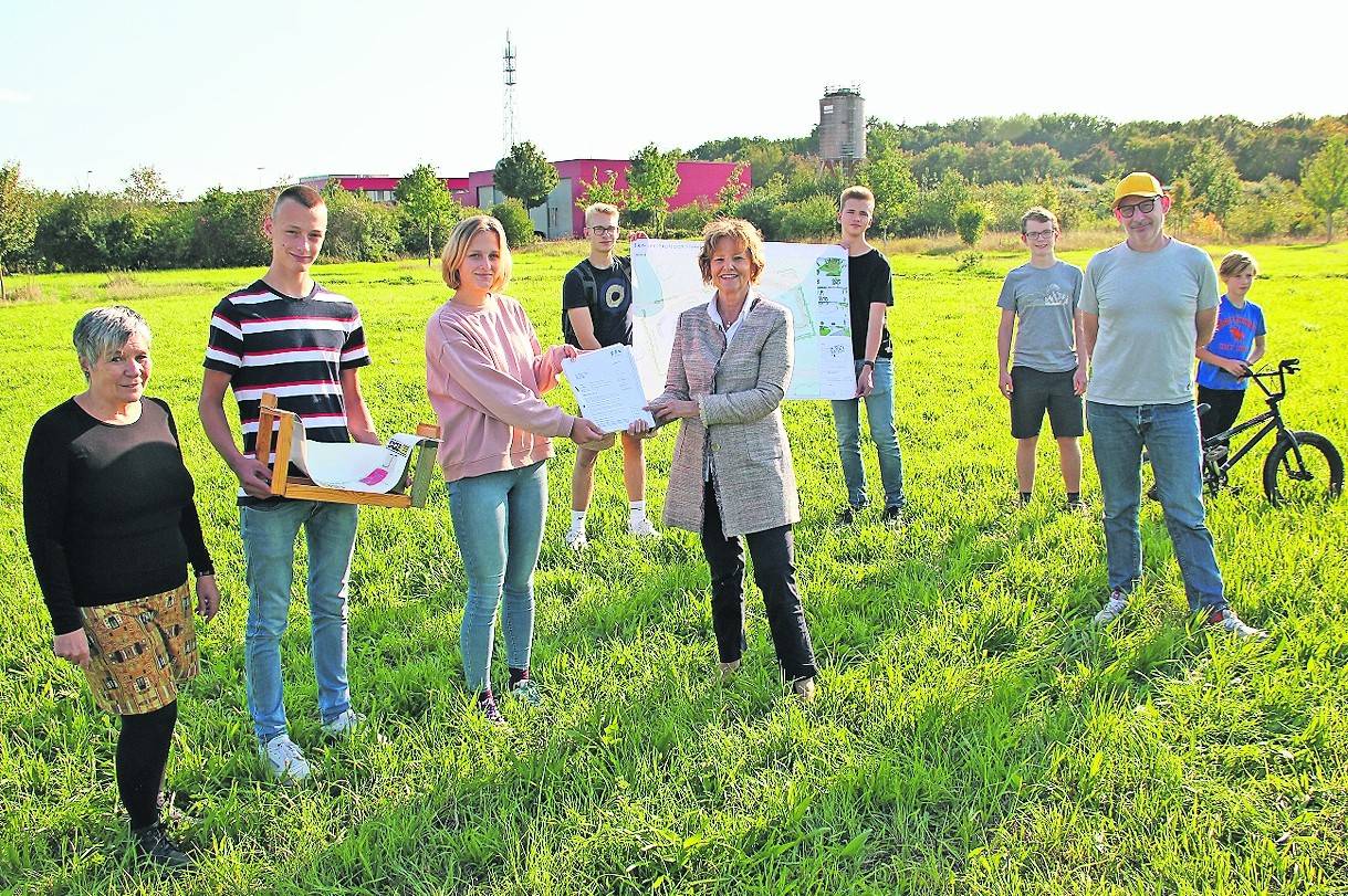  Bürgermeisterin Angelika Mielke-Westerlage überreicht die Baugenehmigung an Ulla Bundrock-Muhs von der „querkopf-akademie“ (v.l. ) sowie die Jugendlichen Florian und Nele Kohtes, Dennis Mardanis, Jan Grützmacher, Quentin Jörgens und Mika Schiffer, die das Projekt von Beginn an unterstützen. Landschaftsarchitekt Ralf Maier (2.v.r) hat den Entwurf für den Skate- und Bikepark erstellt. 