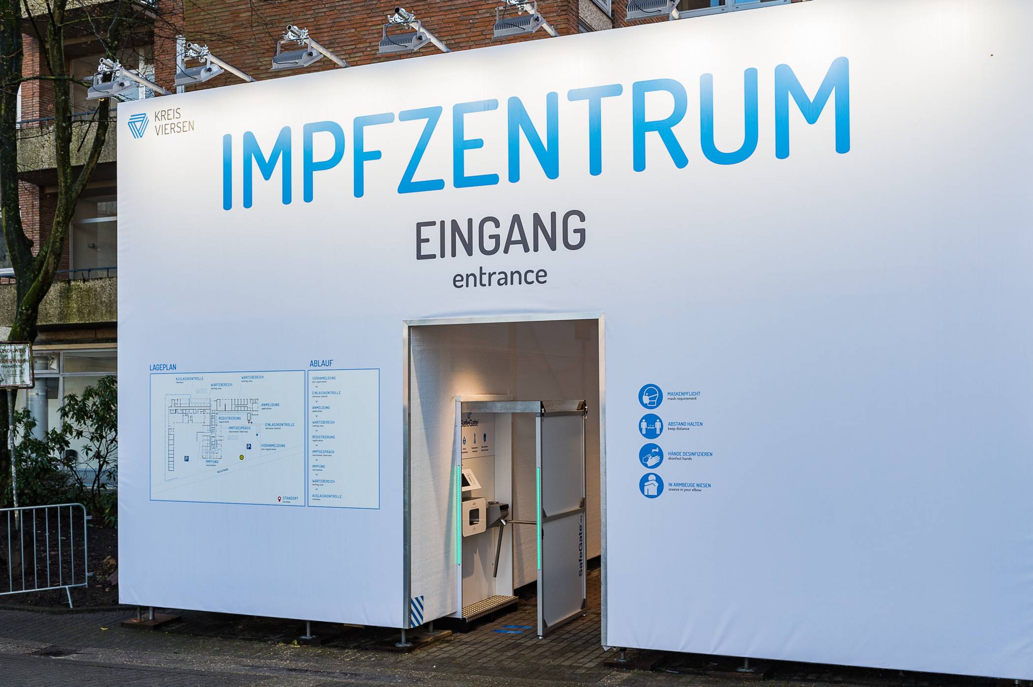  Über diesen Eingang erreichen die Impfberechtigten das Impfzentrum des Kreises Viersen. Nur wer einen Termin vereinbart hat, keine Krankheitssymptome zeigt und Mund-Nasen-Schutz trägt, erhält am Drehkreuz Einlass ins Gebäude.  