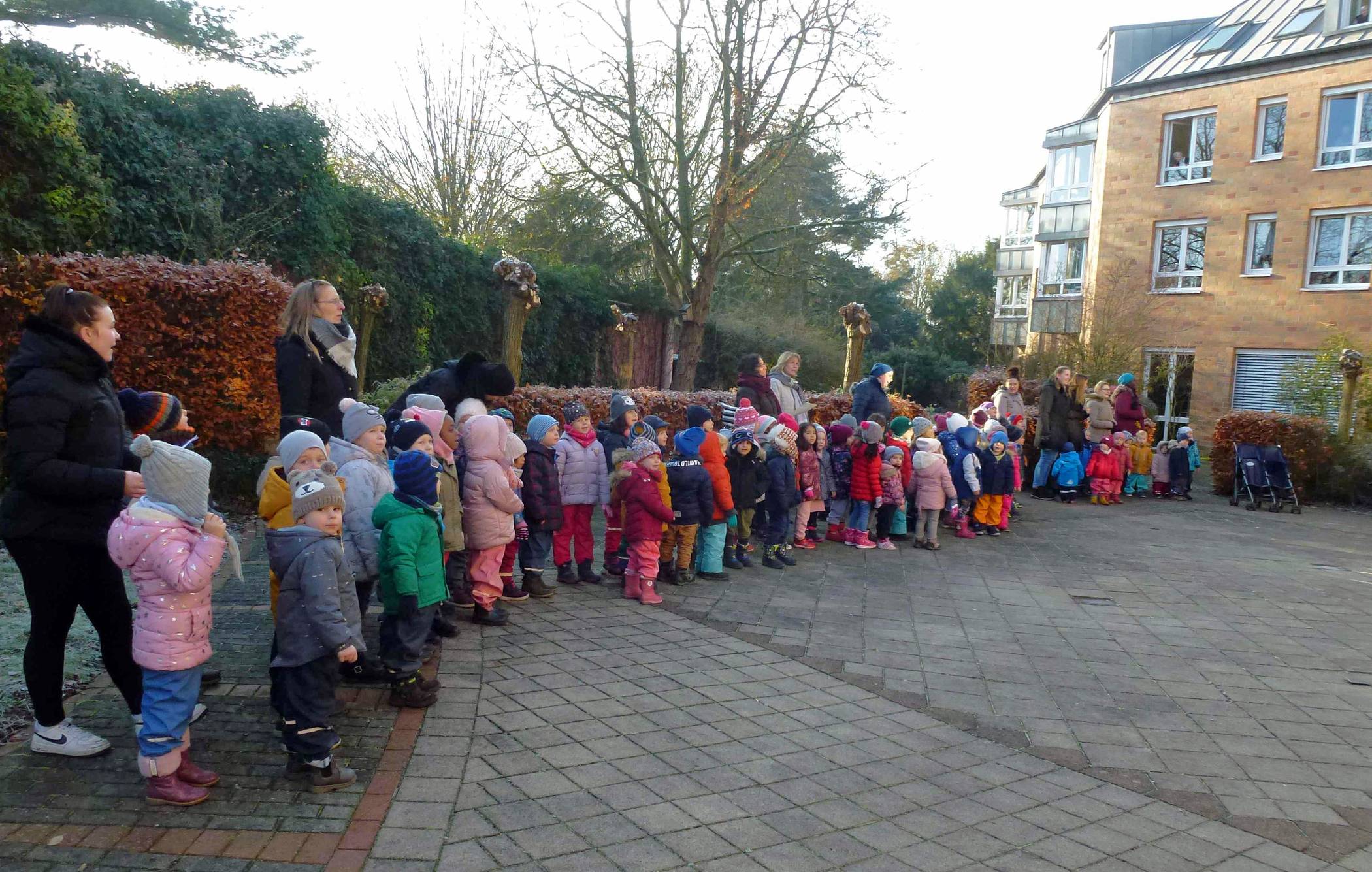 Im Garten des Seniorenzentrums sangen die Kinder der Kita Rüttgersweg Weihnachtslieder. Die Bewohner hörten an den Fenstern oder auf den Balkonen ihrer Wohnungen zu.