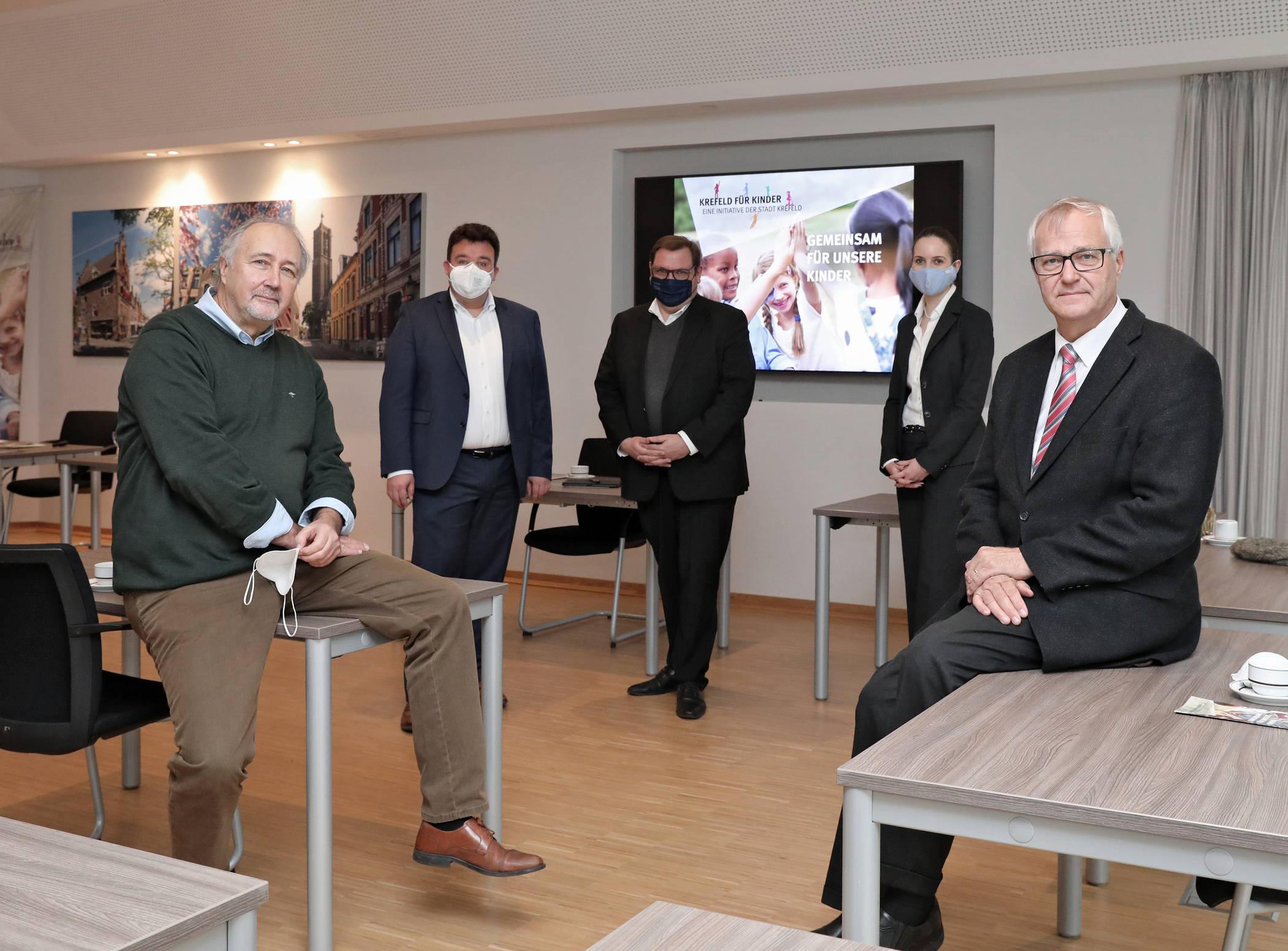 Joachim Watzlawik (l.) übernimmt das Amt des  Koordinators der Initiative „Krefeld für Kinder“ von seinem Vorgänger Gregor Micus (r.). Oberbürgermeister Frank Meyer (Mitte) und Dezernent Markus Schön (hinten l.) gratulieren. Dabei auch die Koordinatorin für Kommunale Präventiosnketten Sabrina Lesch. Foto: Jochmann